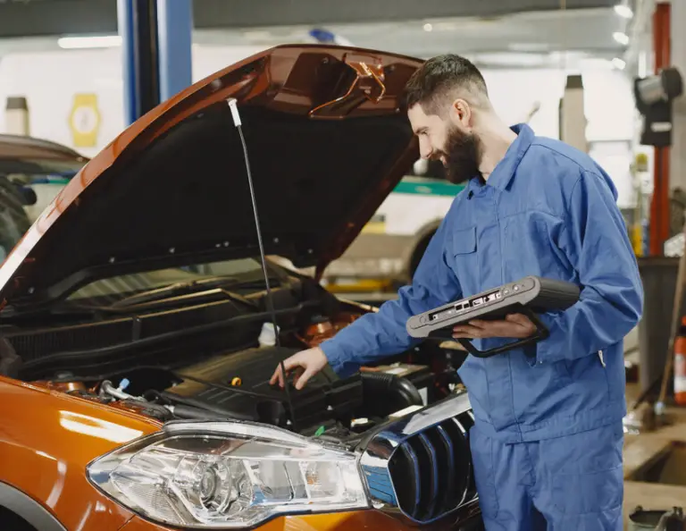 Mechanic Working Under the Hood of Car