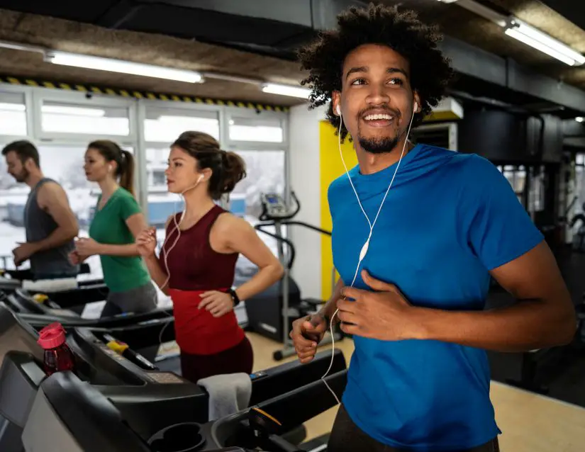 meet physical activity guidelines with aerobic exercise, as depicted here with 4 individuals running on treadmills. 