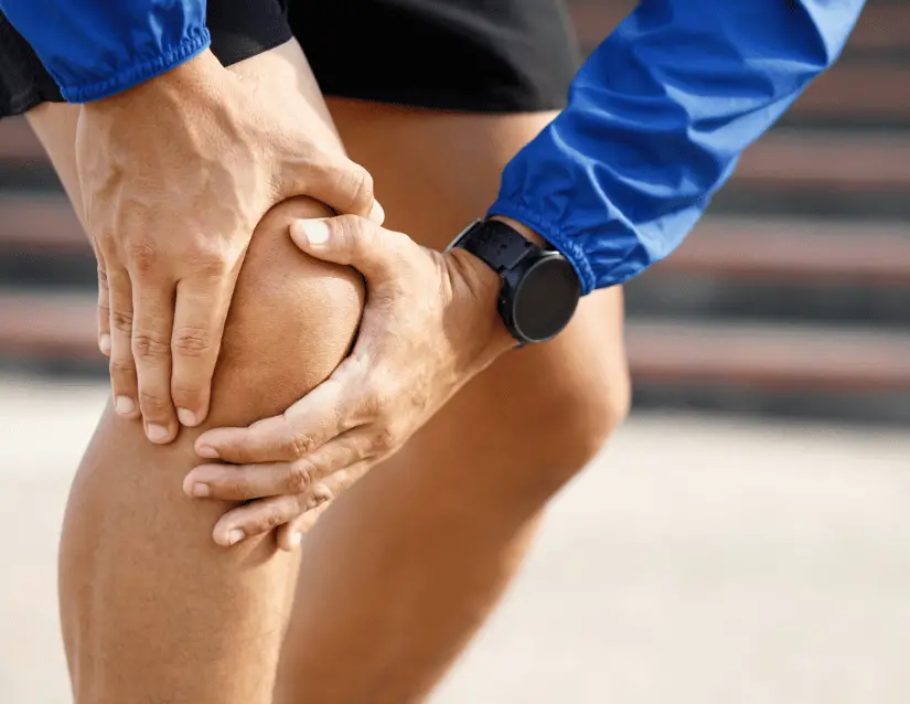 knee osteoarthritis rehab relieves pain around the knee joint, exemplified by a running clutching the front of his knee in pain