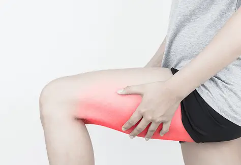 woman holding sore hamstring which benefits from heat therapy