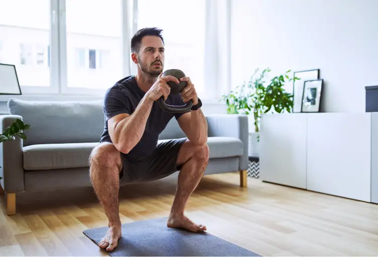 Showing man performing the squat exercise with kettlebell Goblet squat variation
